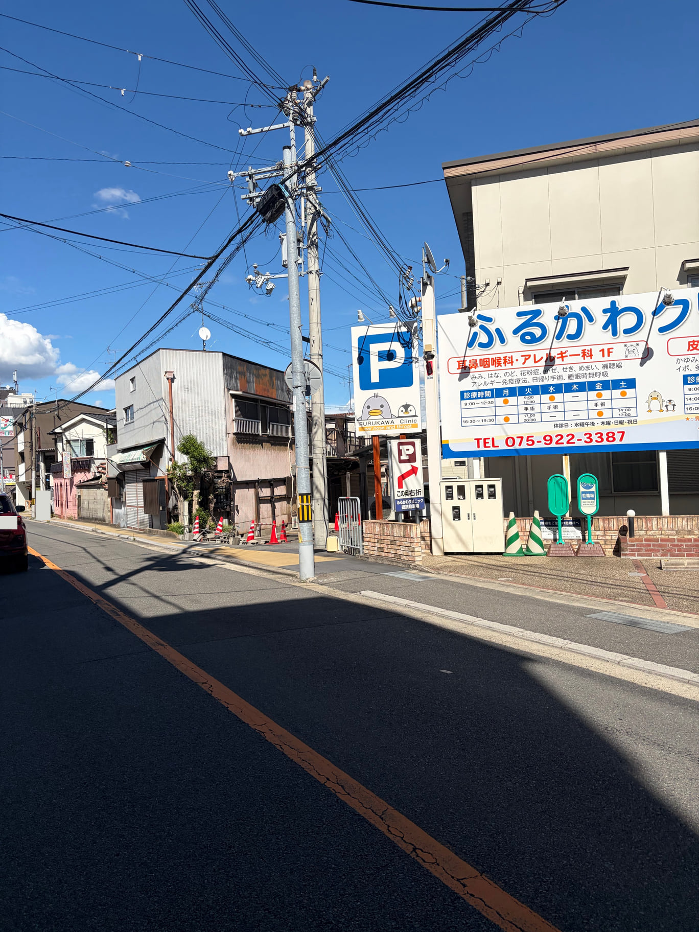 青いP看板の左横にある細い道が、医院東側駐車場への入口。矢印が入口の位置を示しています。