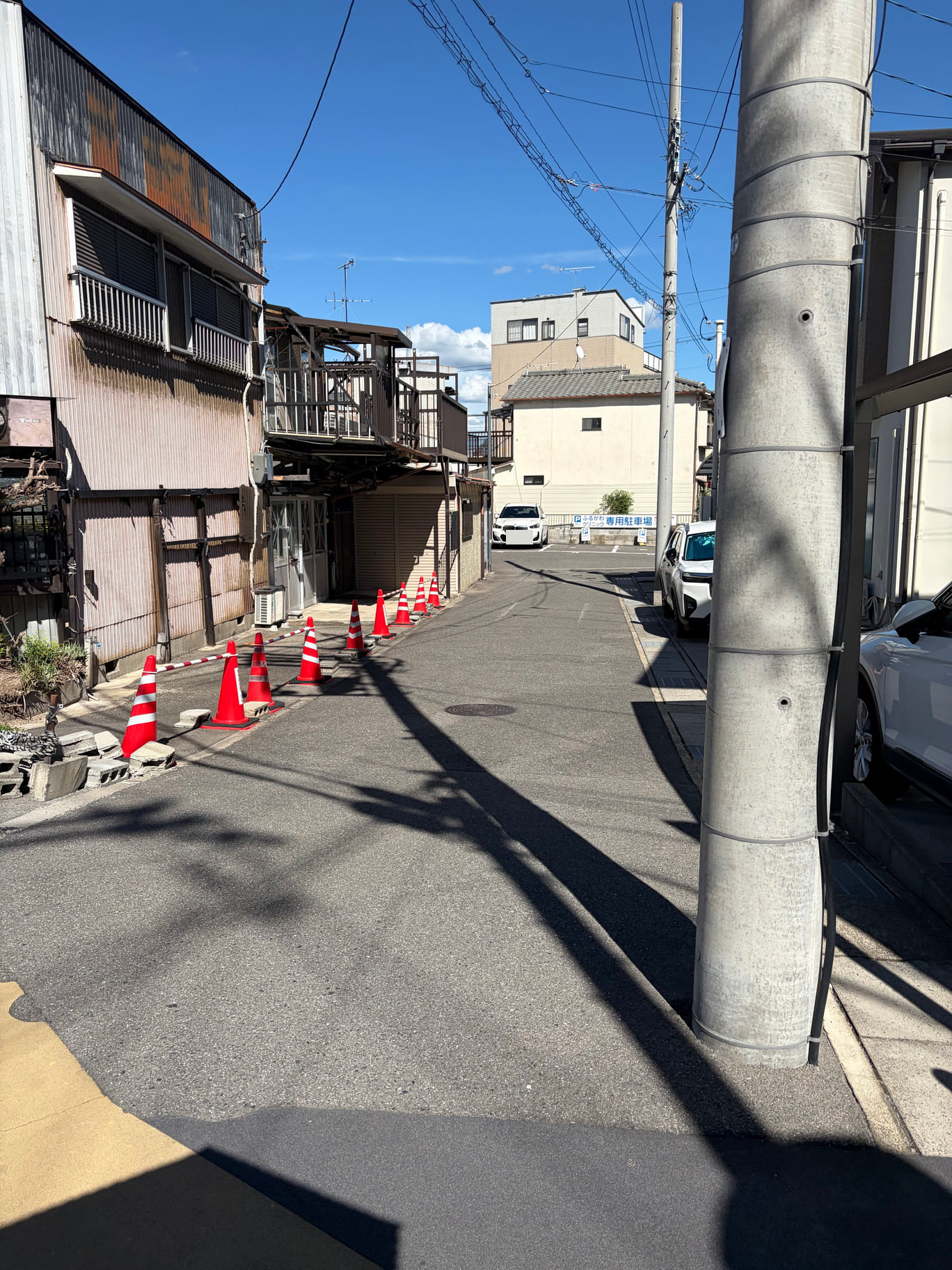 入口から奥を見る。電柱の左側の細い道を、正面に見える専用駐車場の看板まで直進します。